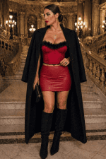 Bustier rouge carmin à plumes porté avec mini jupe rouge cerise au Palais Garnier à Paris dans le grand escalier