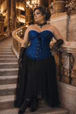 Corset bleu roi brocart gothique romantique chic porté par une femme élégante au Palais Garnier sur le grand escalier en marbre, style éditorial haute couture
