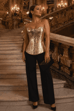 Femme portant un corset gothique moderne doré effet serpent avec pantalon noir taille haute au Palais Garnier escalier