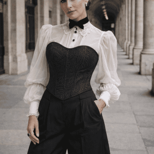 corset gothique noir motif celtique porté avec chemise blanche mousseline manches bouffantes et pantalon tailleur large noir sous les arcades du palais royal paris