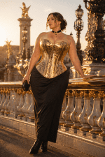 modèle grande taille 4xl portant un corset gothique doré effet serpent à 7 buscs au pont alexandre iii à paris golden hour, jupe longue noire taille haute et look victorien moderne