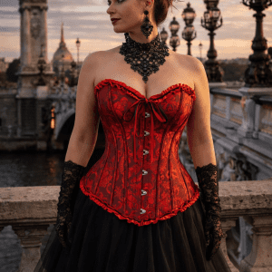 corset gothique romantique rouge en brocart à motifs baroques ton sur ton porté avec jupe en tulle noir sur le pont alexandre III au coucher de soleil