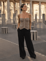 Bustier corset beige et marron pied-de-poule porté avec un pantalon tailleur noir fluide au Palais Royal devant les colonnes de Buren, style mode éditorial chic et sophistiqué.