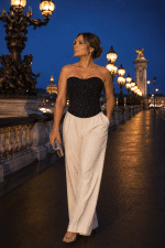 Femme portant un bustier corset souple noir à strass avec pantalon palazzo blanc au Pont Alexandre III à Paris