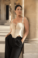 top corset neo-victorien beige a lacets porté avec un pantalon noir fluide sous les arcades Galerie Valois du Palais Royal à Paris