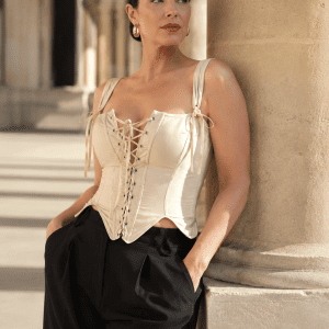 top corset neo-victorien beige a lacets porté avec un pantalon noir fluide sous les arcades Galerie Valois du Palais Royal à Paris