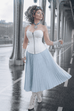 Corset blanc en similicuir porté avec jupe plissée bleu pastel au Pont Bir-Hakeim style steampunk élégant