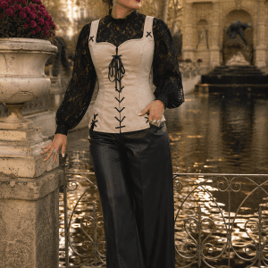 Femme élégante de 45 ans portant un corset bustier blanc cassé style pirate renaissance avec blouse noire en dentelle et pantalon palazzo noir au Jardin du Luxembourg à Paris