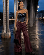 Corset bustier gothique noir effet latex porté avec un pantalon large bordeaux au Pont Bir-Hakeim à Paris dans une ambiance mode éditoriale cyber goth haute couture.