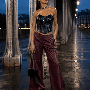 Corset bustier gothique noir effet latex porté avec un pantalon large bordeaux au Pont Bir-Hakeim à Paris dans une ambiance mode éditoriale cyber goth haute couture.