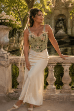 Femme élégante de 45 ans portant un corset bustier fleuri vert sauge avec jupe longue satin crème au bord de la Fontaine Médicis au Jardin du Luxembourg
