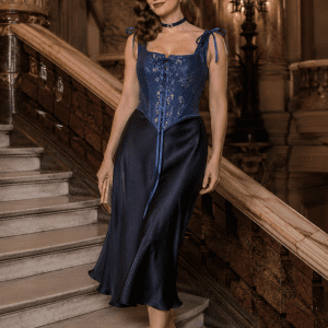 modèle femme 40 ans portant un corset jean bleu fleuri vintage à bretelles style renaissance avec jupe satin bleu nuit au Palais Garnier