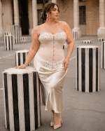 Corset victorien beige rosé grande taille porté avec une jupe satin champagne au Palais Royal parmi les colonnes de Buren