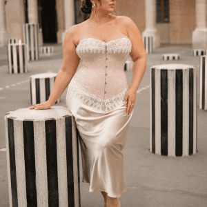 Corset victorien beige rosé grande taille porté avec une jupe satin champagne au Palais Royal parmi les colonnes de Buren