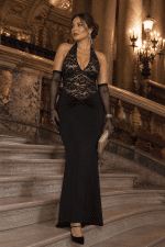 Robe bustier longue noire en dentelle licou avec dos nu portée sur un escalier en marbre au Palais Garnier à Paris