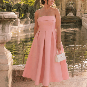 Femme portant une robe bustier midi rose trapèze effet corset devant la Fontaine Médicis au Jardin du Luxembourg à Paris