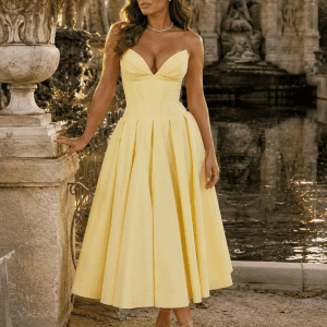 Robe cocktail jaune beurre midi effet corset photographiée à la Fontaine Médicis du Jardin du Luxembourg à Paris dans une lumière dorée matinale