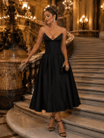Femme portant une robe cocktail noire midi bustier effet corset au grand escalier du Palais Garnier à Paris