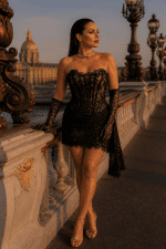 Robe corset mini en dentelle florale noire portée au Pont Alexandre III à Paris, look élégant avec gants dentelle et sandales dorées