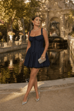 Robe corset mini patineuse marine portée devant la fontaine Médicis au jardin du Luxembourg à Paris, photo éditoriale golden hour élégante