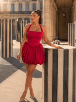 Robe courte bustier corset fuchsia à jupe boule portée au Palais-Royal devant les colonnes de Buren à Paris.