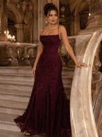 Femme de 40 ans portant une robe longue corset bordeaux en tissu dévoré dans le grand escalier du Palais Garnier à Paris.