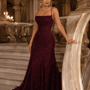 Femme de 40 ans portant une robe longue corset bordeaux en tissu dévoré dans le grand escalier du Palais Garnier à Paris.