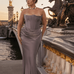 Femme élégante portant une robe longue grise satinée drapée style corset au Pont Alexandre III à Paris pendant la golden hour avec détails dorés et ambiance éditoriale luxe.