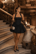 Femme portant une robe mini bustier noire dos nu à jupe ballon au Palais Garnier dans une ambiance mode éditoriale glamour