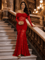 Femme portant une robe longue sirène rouge en dentelle au Palais Garnier avec pochette dorée et escalier de marbre