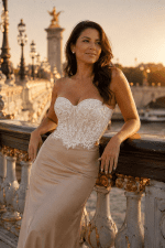 Femme portant un bustier soutien-gorge blanc en dentelle florale avec bonnets à armatures et jupe satinée champagne sur le Pont Alexandre III à Paris.
