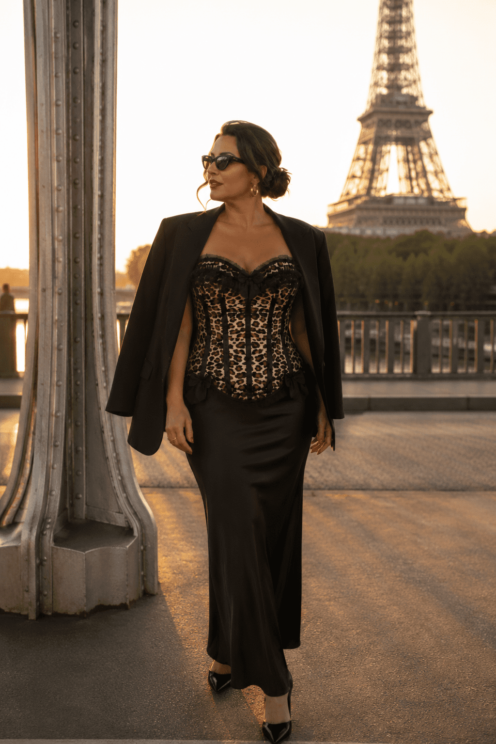 Corset bustier imprimé léopard vintage porté avec une jupe longue noire et un blazer oversize noir devant la Tour Eiffel à Paris.