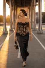 Femme de 45 ans portant un corset bustier imprimé léopard vintage avec jupe longue noire en satin au Pont Bir-Hakeim à Paris.