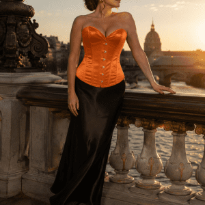 Femme de 45 ans portant un corset bustier satin orange brûlé avec jupe maxi noire au Pont Alexandre III au coucher du soleil.