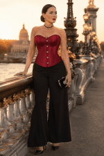 Femme de 45 ans portant un corset bustier satin rouge gothique chic avec pantalon palazzo noir au pont Alexandre III à Paris au coucher du soleil
