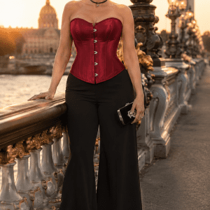 Femme de 45 ans portant un corset bustier satin rouge gothique chic avec pantalon palazzo noir au pont Alexandre III à Paris au coucher du soleil