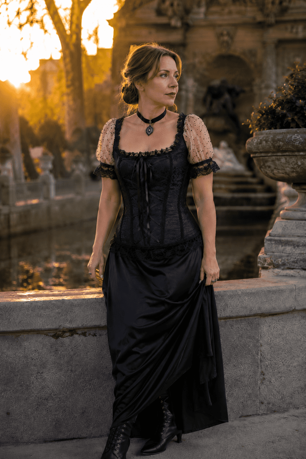 Corset victorien romantique noir et blanc porté à la Fontaine Médicis à Paris, avec manches bouffantes en tulle blanc à pois, dentelle noire, jupe longue en satin noir et bottines victoriennes, photographié à la golden hour.
