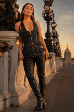 Corset licou noir en brocart floral et similicuir noir avec chaînes décoratives dorées, fermeture zippée à l'avant et ceinture intégrée à anneau métallique.