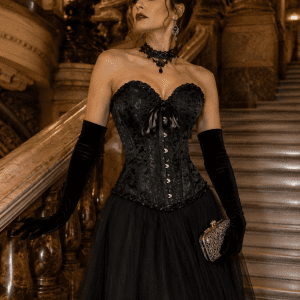 Corset néo-victorien noir bustier vintage en brocart baroque ton sur ton porté avec une longue jupe en tulle noir sur le grand escalier du Palais Garnier à Paris.