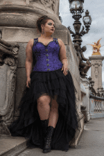 corset steampunk violet en brocart jacquard à motifs baroques avec dos haut, fermeture à crochets métalliques sur le devant et bretelles réglables, porté avec une jupe asymétrique en tulle noir au pont Alexandre III à Paris