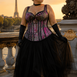 Femme élégante de 40 ans en corset steampunk multicolore grande taille avec jupe longue en tulle noir au pont Alexandre III à Paris au coucher du soleil.