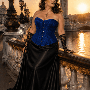 Corset vénitien bleu royal grande taille en jacquard satiné à motif floral ton sur ton, avec fermeture à busc métallique sur le devant, porté avec une jupe longue noire élégante au Pont Alexandre III à Paris au coucher du soleil.