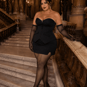 Femme portant un ensemble corset bustier gothique grande taille noir à rayures tennis avec mini-jupe assortie dans le grand escalier du Palais Garnier.