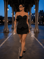 Femme portant un ensemble corset bustier gothique noir à rayures tennis avec mini-jupe assortie au Pont Bir-Hakeim à Paris.