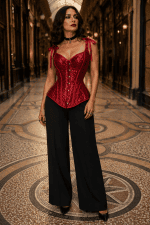 Corset bustier gothique romantique rouge rubis à sequins scintillants avec décolleté en cœur, bretelles à nouer, coupe à basque et pantalon palazzo noir à la Galerie Vivienne à Paris.