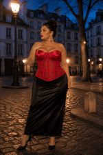 Femme élégante portant un corset bustier rouge transparent grande taille avec jupe satinée noire à la place dauphine à Paris