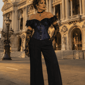 Corset gothique bleu nuit en satin et dentelle noire porté avec un pantalon palazzo noir devant le palais garnier à Paris durant la golden hour du soir