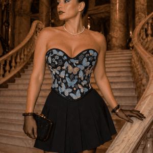 Corset bustier Renaissance en brocart noir à papillons bleus et dorés porté avec une jupe noire plissée