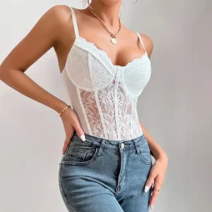 Body corset en dentelle florale blanche avec bonnets structurés et bretelles fines, porté avec un jean délavé sur fond neutre.